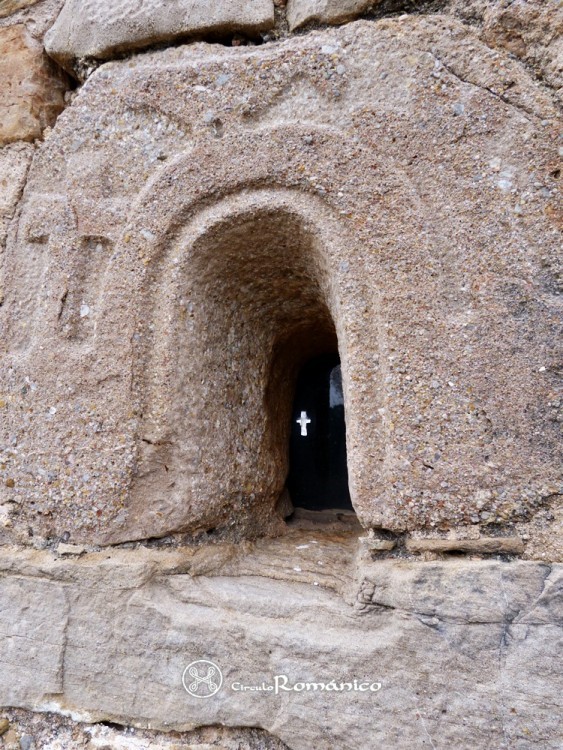 Montner. Sant Esteve de Tubau. Arquivolta decorada con una cruz y un pájaro